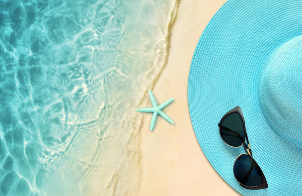 Sombrero de verano con gafas de sol. Vista superior, concepto de verano sobre un fondo de playa tropical
. - Foto, Imagen