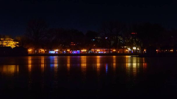 Shichahai-See, Nachtansicht von bunt beleuchteten Gebäuden am Ufer des Sees. - Foto, Bild