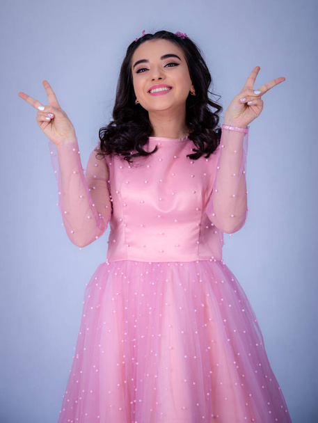 Portrait Of Beautiful Young girle Standing Against blue Background,girl in a pink dress,Happy cheery smiling young cute girl posing isolated, - Φωτογραφία, εικόνα