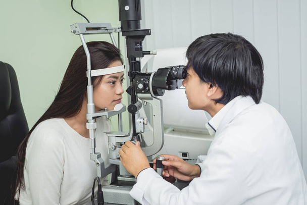 Consulta con un oftalmólogo. Joven mujer asiática y médico
  - Foto, imagen