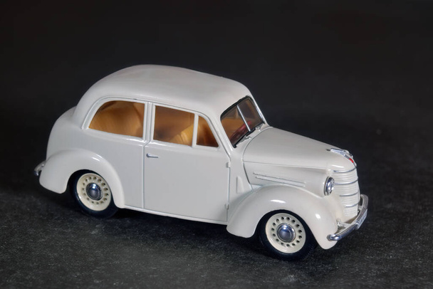 Children's toy car white on a dark background. - Zdjęcie, obraz