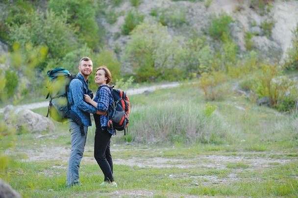 Pari turisteja ajoissa matkan teräksen ja ihailla kauniita vuoristomaisemia. Mies halaa tyttöä. Rakkauden, hellyyden ja virkistyksen käsite
 - Valokuva, kuva