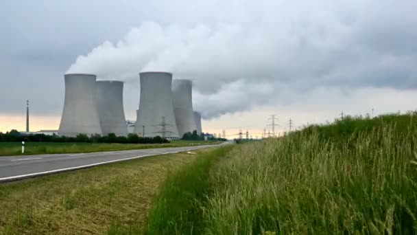 Jaderná elektrárna se čtyřmi kouřícími komíny na zelených přírodních loukách. Včasné video.  - Záběry, video