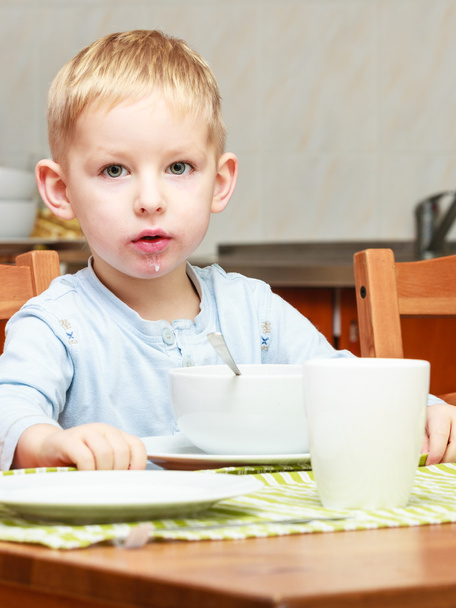 Boy kid child eating corn flakes breakfast meal at the table - Foto, Imagen