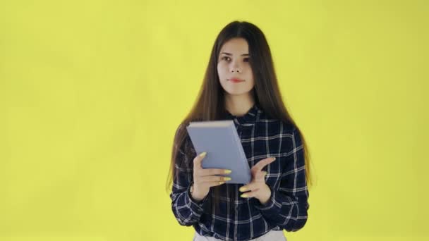 Beautifu thoughtful girl finished reading book isolated on yellow background - Filmati, video