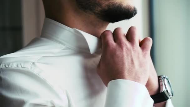 Ein Mann mit Bart korrigiert einen Hemdkragen - Filmmaterial, Video