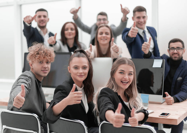 business team sitting at a Desk and showing thumbs up - Zdjęcie, obraz