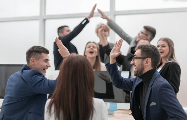 group of young business people giving each other a high five - Foto, Bild