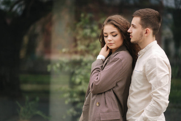 Porträt eines verliebten Paares. Junger Mann und Frau mit lockigem Haar im Freien - Foto, Bild