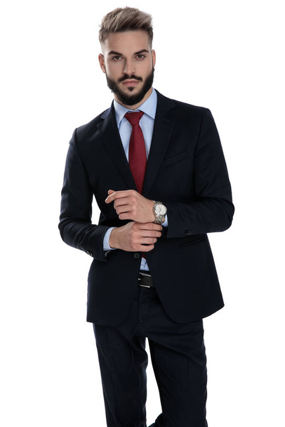 сексуальный молодой бизнесмен организуя часы и стоя изолированы на белом фоне
 - Фото, изображение