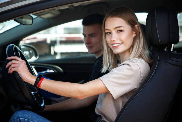 Driving instructor and woman student in examination car. - 写真・画像