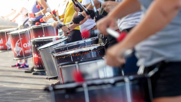 Closeup photo of of street artists playing on drums on the city street during festival or carnaval - Photo, Image