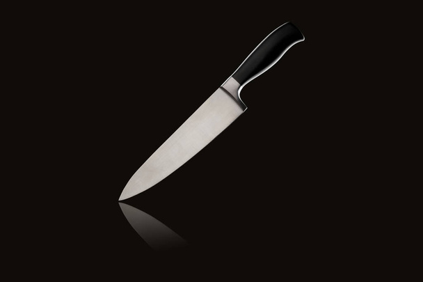 Sharp large kitchen knife with handle on black isolated background with reflection - Photo, Image