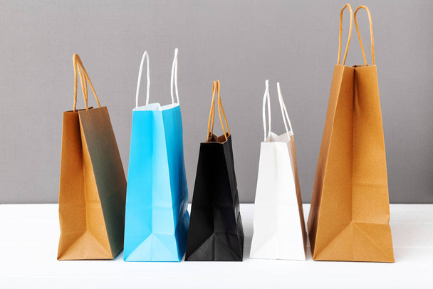 Assortment of different colorscraft paper bags. Shopping Mockup bags paper packages on white table gray background with copy space. Shopping, sale, Food delivery service - Photo, Image