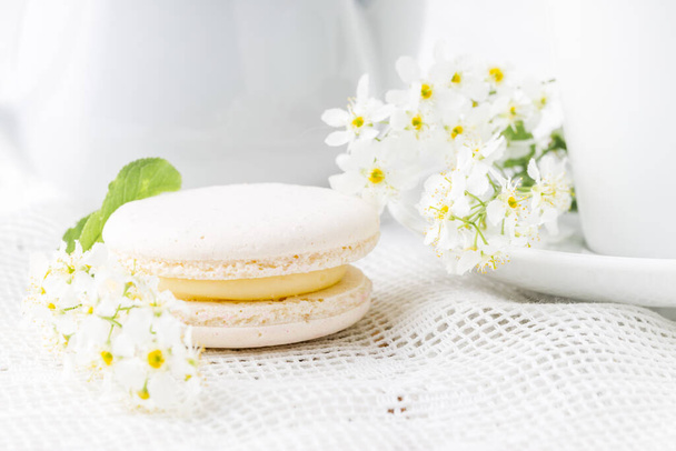 White french macaroon close up on table with flowers - Фото, зображення