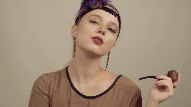 Girl in the 90s style, chicago style. Hat, headband with decorative feathers on the head. Incredible jewelry, long earrings with diamonds, coquette. Smiles and laughs. smile dance pouse - Footage, Video
