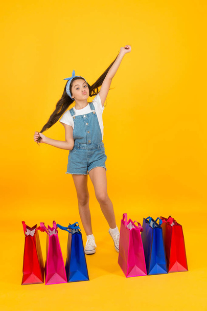 Home shopping. happy childhood. kid with package bags. real shopaholic. black friday sale. special offer for you. buy goods online during coronavirus lockdown. small girl after successful shopping - Фото, изображение