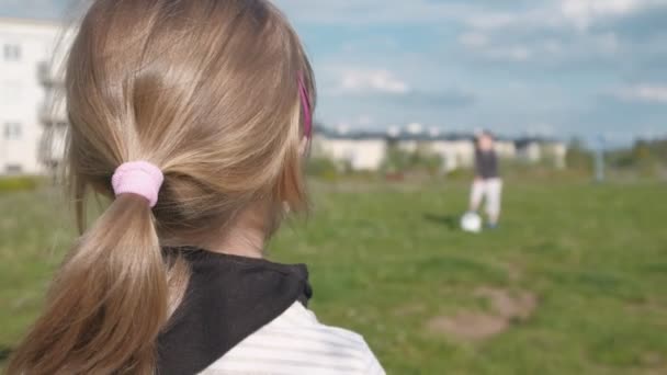 Ein Mädchen auf dem Fußballplatz blickt ihre Gegnerin an. Ein Blick von hinten. Zeitlupe - Filmmaterial, Video