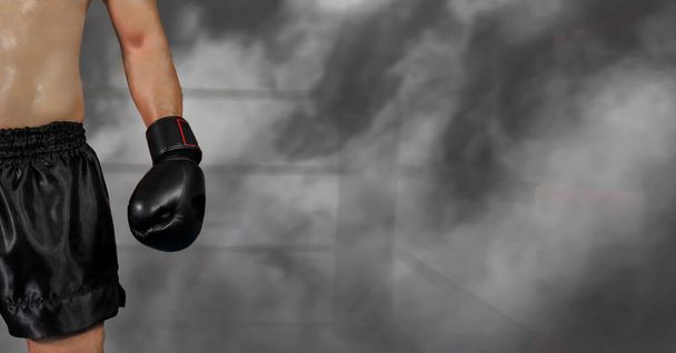 male boxer with black glove on boxing stage in dark foggy background, selective focused - Fotoğraf, Görsel