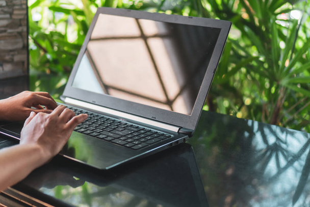 Kobieta ręka za pomocą laptopa do pracy na biurku z czystym tle natury. Biznes, finanse, maket giełdowy i koncepcja sieci społecznościowych. - Zdjęcie, obraz