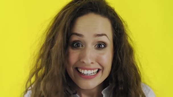 Young beautiful Caucasian woman is very happy on yellow background. Woman heard the good news - Footage, Video