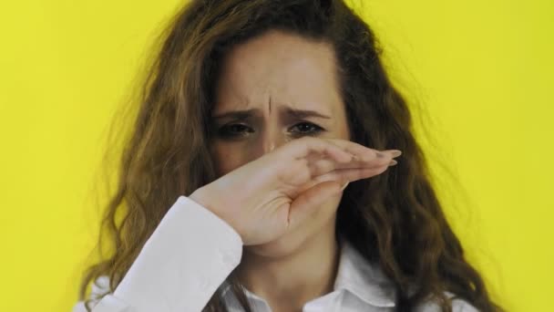 Una joven hermosa mujer llora en un estudio de pantalla amarilla
 - Metraje, vídeo