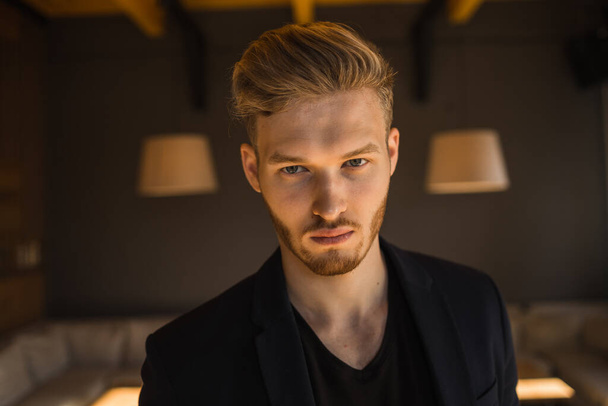 successful beautiful young man blond is located in a modern loft room, hookah - Zdjęcie, obraz