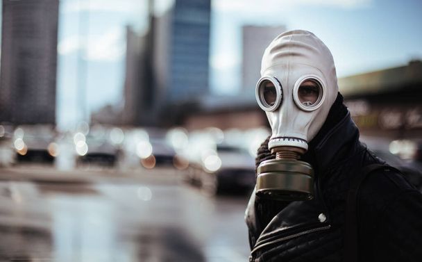 casual young man in a gas mask looking at the camera - Фото, изображение