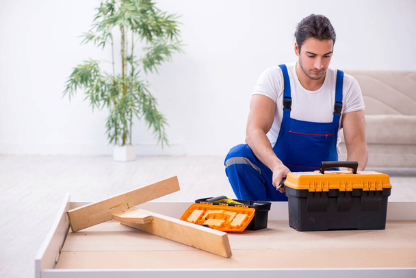 Giovane imprenditore maschio installazione di mobili a casa - Foto, immagini