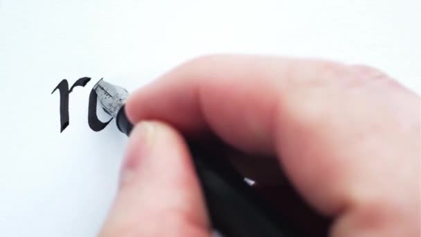 Sanan "kosto" kirjoittaminen. Miehen kädet kirjoittavat kynällä. Kalligrafian lähikuva
. - Materiaali, video