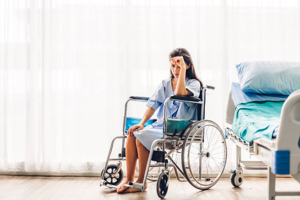 Γυναίκα ασθενής σοβαρή κατάθλιψη και αίσθημα πονοκέφαλο κάθονται σε αναπηρική καρέκλα στο νοσοκομείο.υγειονομική περίθαλψη και ιατρική - Φωτογραφία, εικόνα