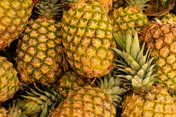 Ananas ist reif. Hawaiianische Ananas Hintergrund. Viele Ananasfrüchte im Hintergrund. - Foto, Bild