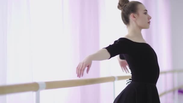 A balerina felmelegszik, és a balett konditeremben megfeszül a korláton. - Felvétel, videó