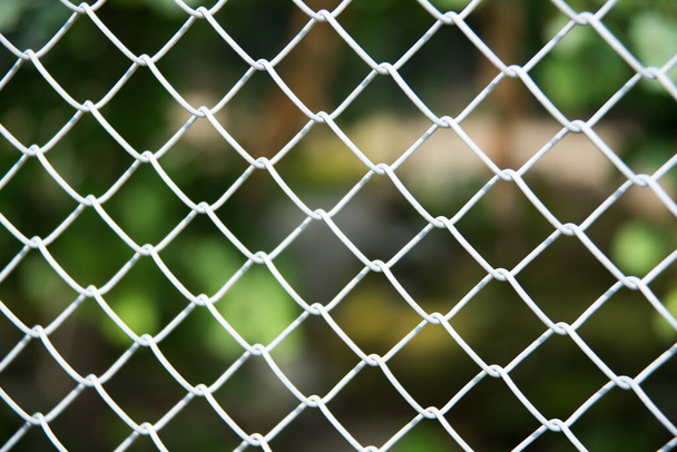 close up of a white metal wire cage frame on out of focus foliage in the background - Photo, Image