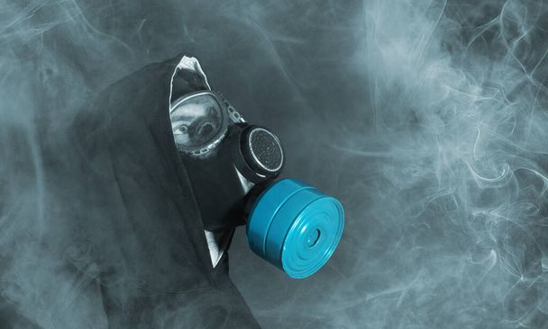 Man in a gas mask in the smoke, blue smoke - Φωτογραφία, εικόνα
