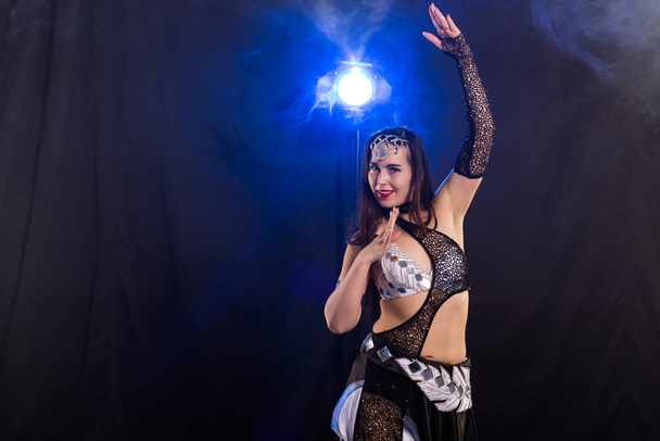 Portrait of a woman in oriental costume performing belly dance. Tribal fusion dance concept. - Photo, Image