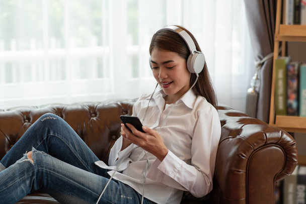 Portrait of Young Asian woman enjoy listening to music with headphones, happy and relaxing time - Photo, Image