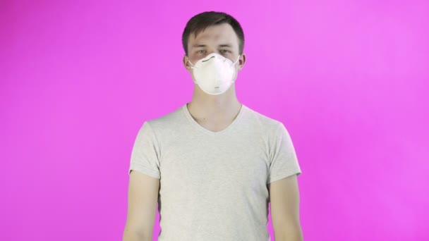 Fiatal férfi aktivista maszk az arcon és a Think Planet poszter rózsaszín háttér - Felvétel, videó