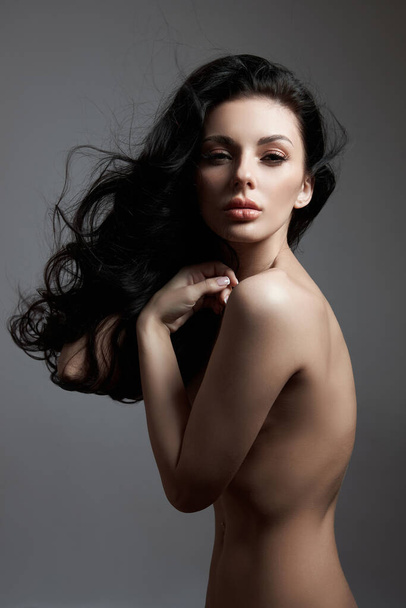 Sexy fashion nude woman with long hair, curly strong hair of a brunette girl. Natural cosmetics for hair care, strong roots - Zdjęcie, obraz