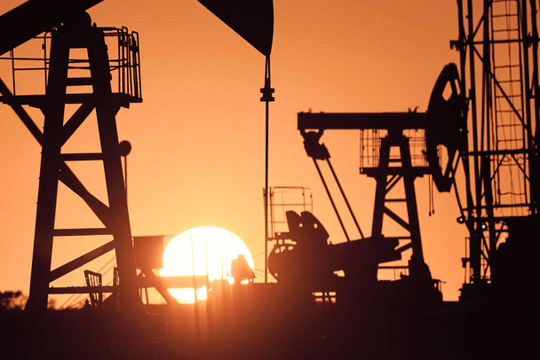 Oliepomp olie tuig energie industriële machine voor aardolie in de zonsondergang achtergrond voor ontwerp. - Foto, afbeelding