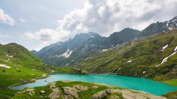 mountain peaks and emerald green alpine lake with moving clouds on the italian Alps - Footage, Video