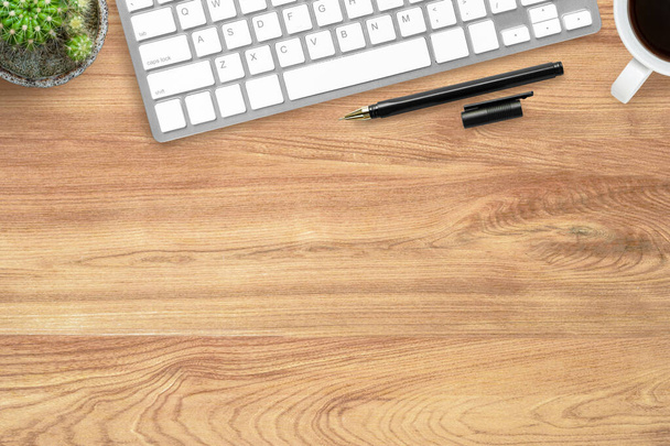 Mesa de escritório de madeira Hipster com teclado de computador, caneta e xícara de café. Vista superior com espaço de cópia, flat lay
. - Foto, Imagem