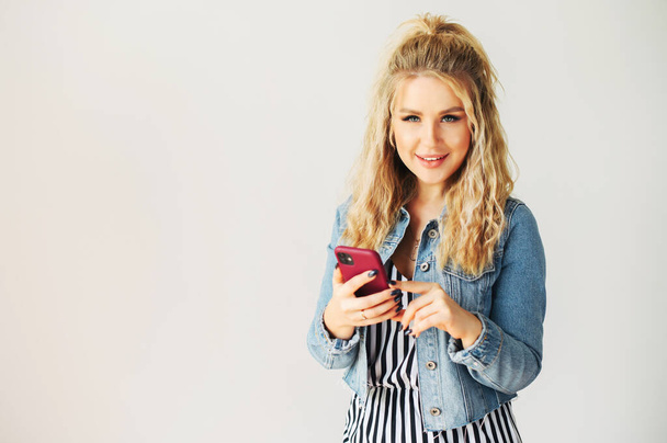 Blonde woman with a smartphone in hands - Photo, Image