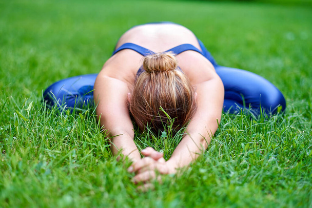 Yoga. Young woman practicing yoga meditation in nature at the park. Health lifestyle concept. - Photo, image