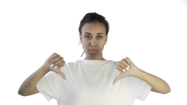 Menina bonita em uma camiseta branca mostra polegar para baixo com ambas as mãos no fundo branco
 - Filmagem, Vídeo