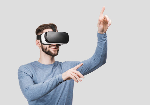 Young man using virtual reality headset studio isolated portrait. VR, future, gadgets, technology concept - Φωτογραφία, εικόνα