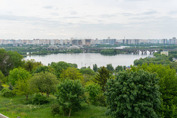 Благочестивий вид на центр Києва, ділові та житлові будівлі, природу в місті, міст і Дніпро. - Фото, зображення