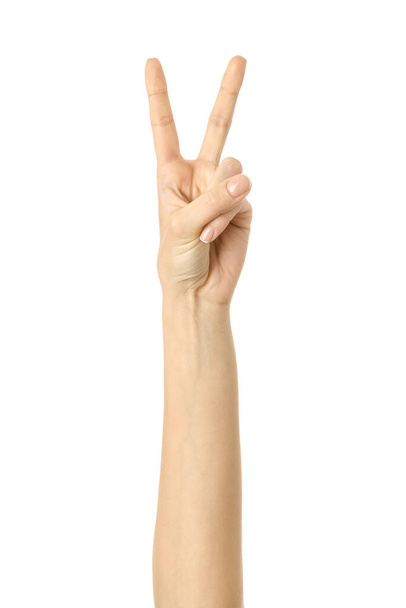 Overwinningsbord. Vrouw hand met Franse manicure gebaar geïsoleerd op witte achtergrond. Deel van serie - Foto, afbeelding