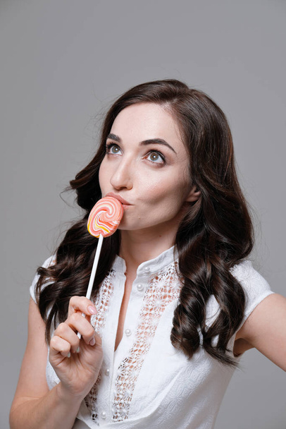 Studio portrait of woman holding colorful lollipop - Фото, зображення