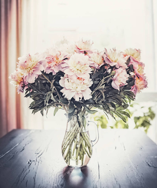 Lovely Peonies bunch in vase on table at window background, Still life - Fotó, kép